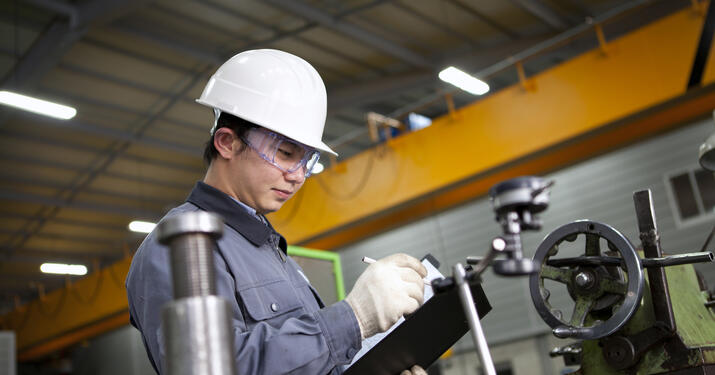 man in hard hat holding a clipboard